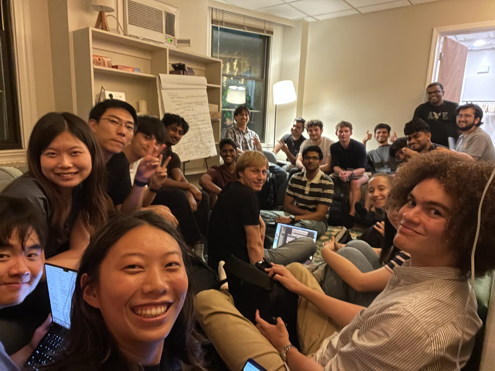 MLn Reading Club, Week 13 — the group gathered on the couches and floor at CASI, with the evening's discussion notes filling the flip chart behind them